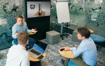 three people sitting in an office and talking to each other